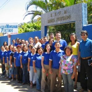 Fachada da EEEM Monsenhor Furtado. Na imagem aparecem os funcionários da escola